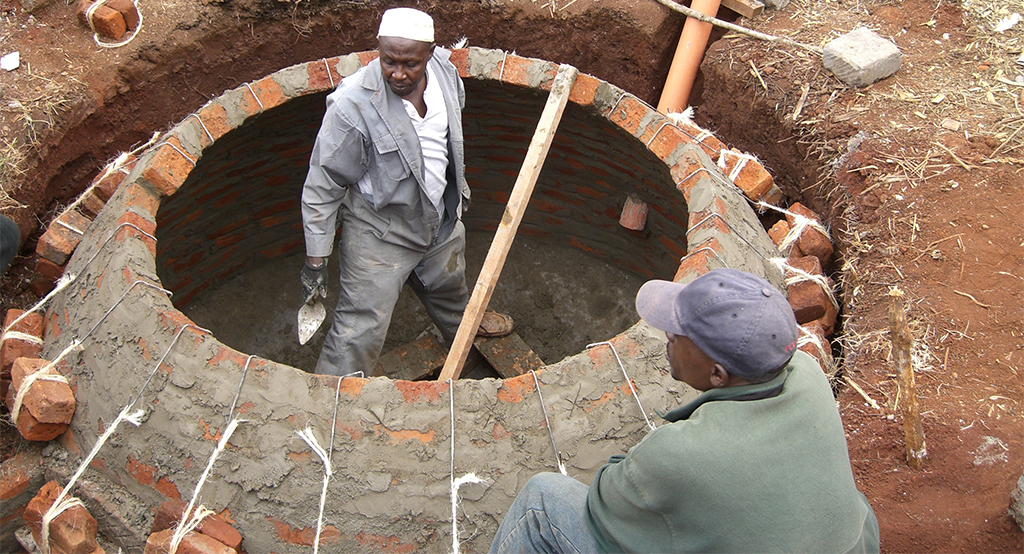 Two men working on biogas facility in Kenia